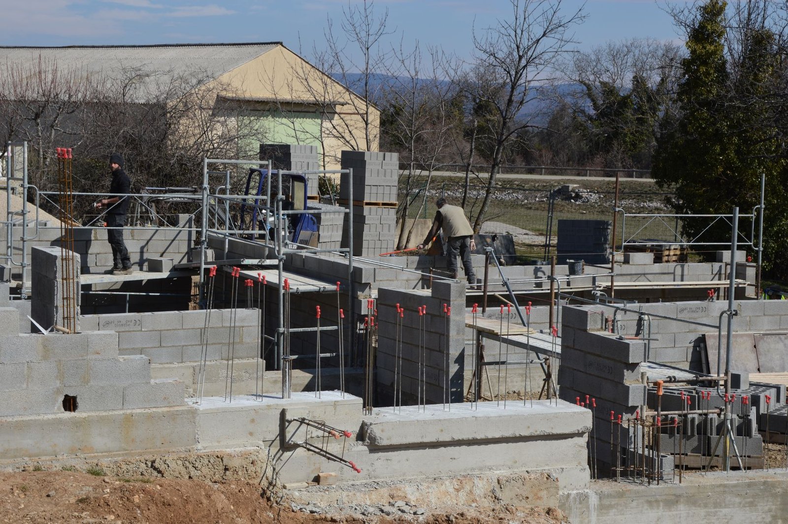 Construction workers building a concrete structure in daylight